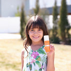 Protetor Solar Mineral Hidratante doTERRA SPF30 — menina morena sorridente no jardim, proteção solar rosto CPTG