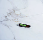 Melaleuca Touch doTERRA Roll-on 10ml — deitado em mármore branco dourado, árvore de chá puro CPTG