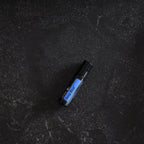 Deep Blue Touch doTERRA Roll-on 10ml — deitado em granito preto texturizado cenital, óleo musão puro CPTG
