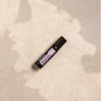 Roll-On Magnólia Touch doTERRA 10ml — deitado em pedra bege com sombras de folhas, aromaterapia natural CPTG