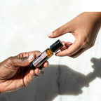 Roll-On Magnólia Touch doTERRA 10ml — duas mãos a passar com luz solar e sombras, óleo essencial magnólia