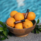 Roll-On Neroli Touch doTERRA 10ml — dois frascos com tigela de laranjas junto à piscina azul, óleo essencial cítrico puro