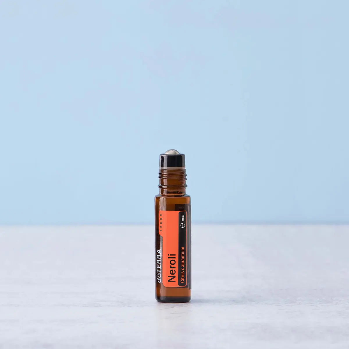 Roll-On Neroli Touch doTERRA 10ml — frasco em mármore branco fundo azul claro, aromaterapia neroli doTERRA Portugal