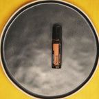 Roll-On Neroli Touch doTERRA 10ml — prato de cerâmica cinzento fundo amarelo vista de cima, óleo essencial CPTG