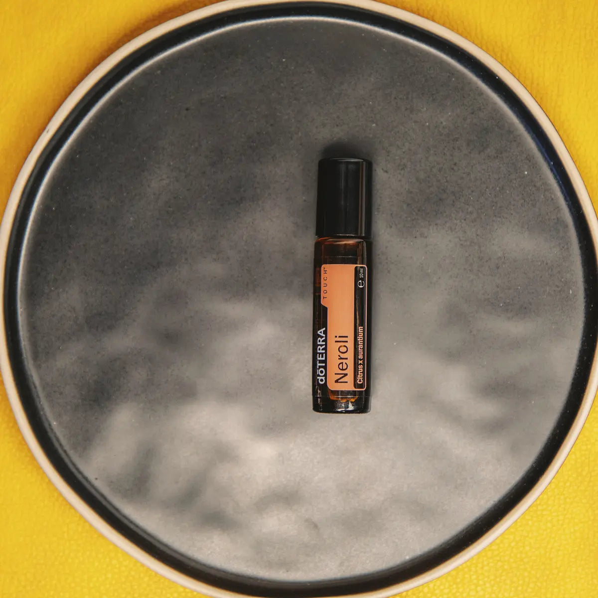 Roll-On Neroli Touch doTERRA 10ml — prato de cerâmica cinzento fundo amarelo vista de cima, óleo essencial CPTG