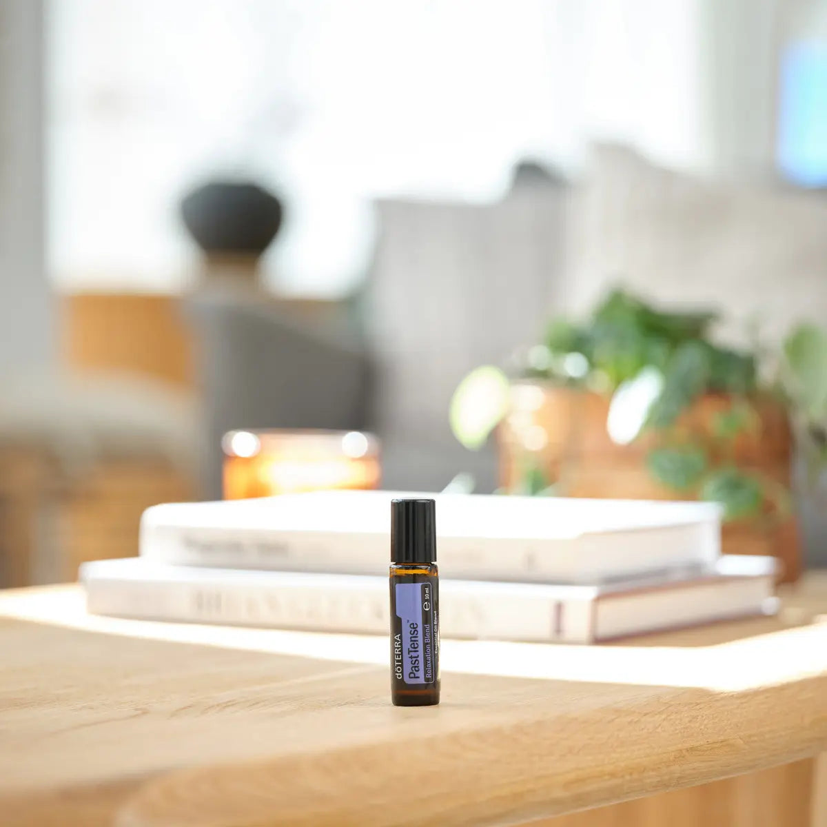 Roll-On PastTense doTERRA 10ml — mesa de madeira com livros e vela na sala, óleo essencial puro CPTG Portugal