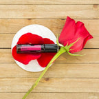 Roll-On Rosa doTERRA 10ml — base branca com rosa vermelha e pétalas em madeira vista de cima, óleo essencial CPTG
