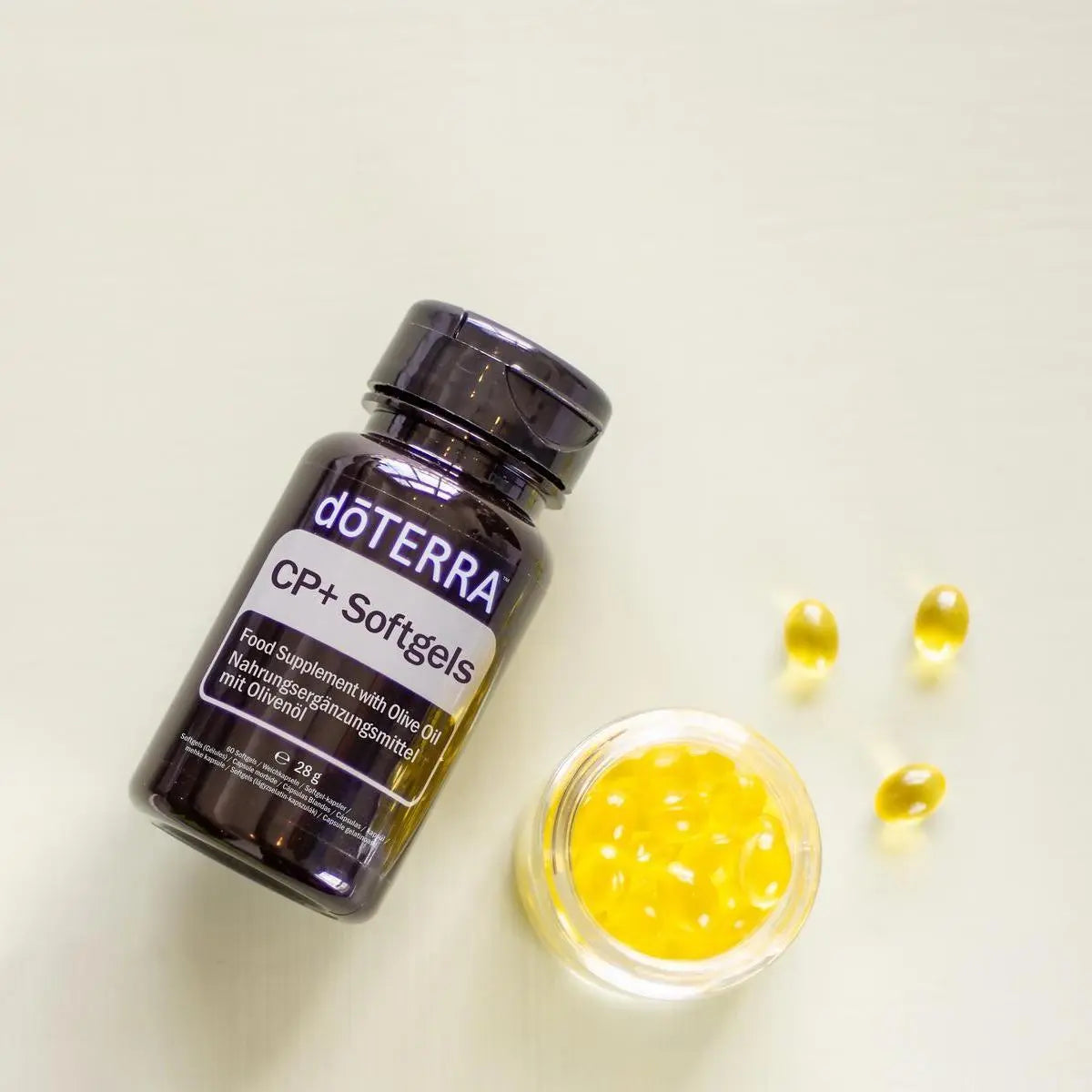 Cápsulas Moles CP+ doTERRA — frasco e softgels em tigela cristal fundo bege, suplemento proteção celular