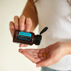 DDR Prime Softgels doTERRA — mãos com frasco aberto e softgel na palma, suplemento renovação celular, bem-estar