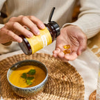 Cápsulas EO Mega+ doTERRA — frasco, mãos e softgels em tigela de sopa, suplemento ómega essencial, bem-estar