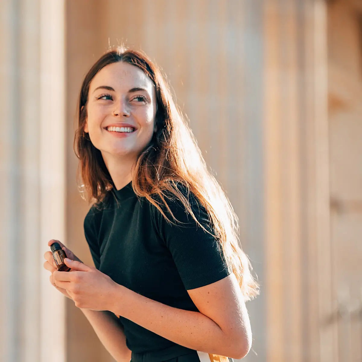 Sistema Meta-PWR doTERRA — mulher morena em exterior com colunas sob luz dourada, lifestyle suplementos bem-estar