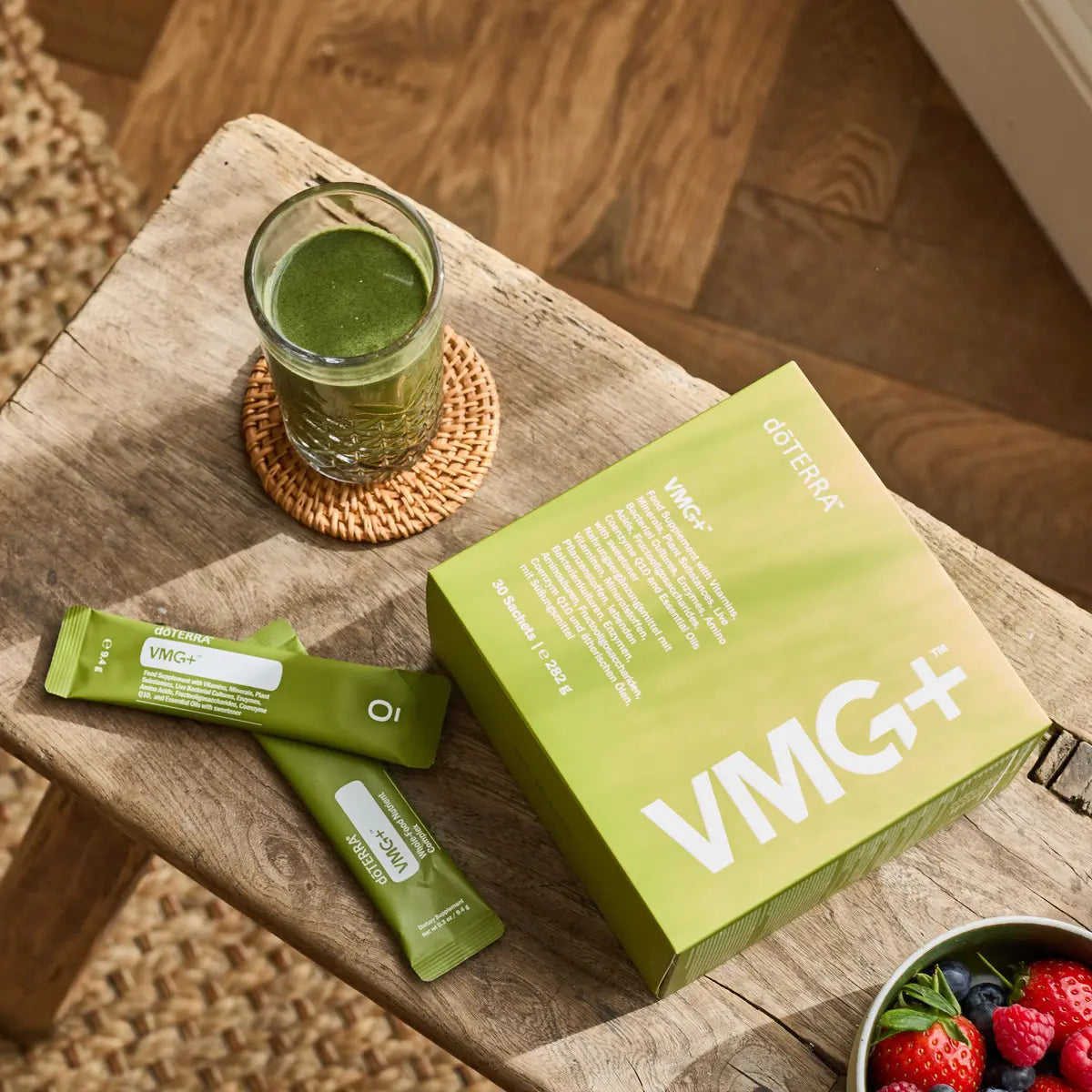 VMG+ doTERRA caixa e saquetas em mesa de madeira com batido verde e frutas — suplemento alimentar vegetal puro com nutrientes essenciais CPTG
