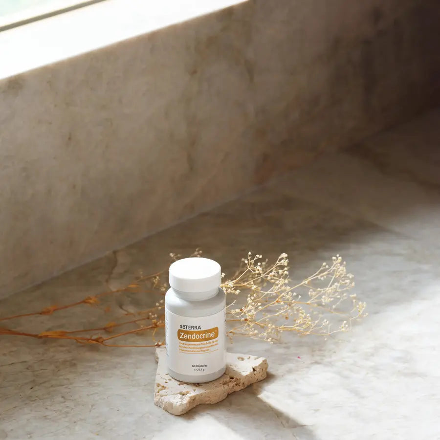 Complexo Zendocrine doTERRA 60 un frasco branco sobre pedra com ramos secos — suplemento detox natural CPTG
