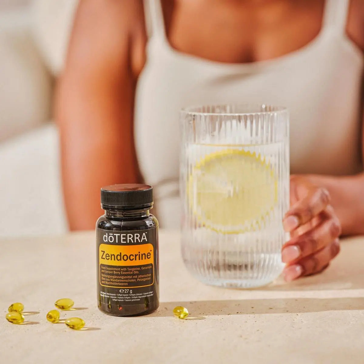 Cápsulas moles Zendocrine doTERRA frasco preto com softgels vaso e limão na bancada — suplemento detox com óleos essenciais CPTG